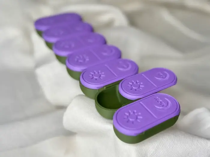 Close-up of the weekly pill organizer with neatly arranged AM/PM compartments, emphasizing its sleek design and functionality.